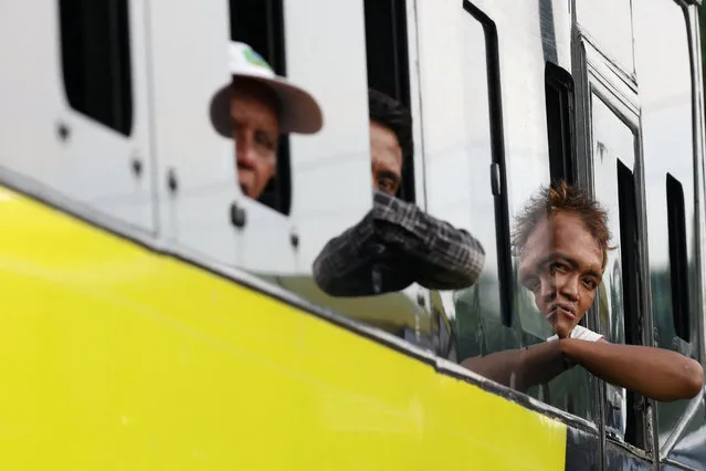 Passengers look through the window of a bus as people return to their hometowns, known locally as “mudik”, ahead of the Eid al-Fitr celebration, at Kampung Rambutan Terminal in Jakarta, Indonesia on April 4, 2024. (Photo by Ajeng Dinar Ulfiana/Reuters)