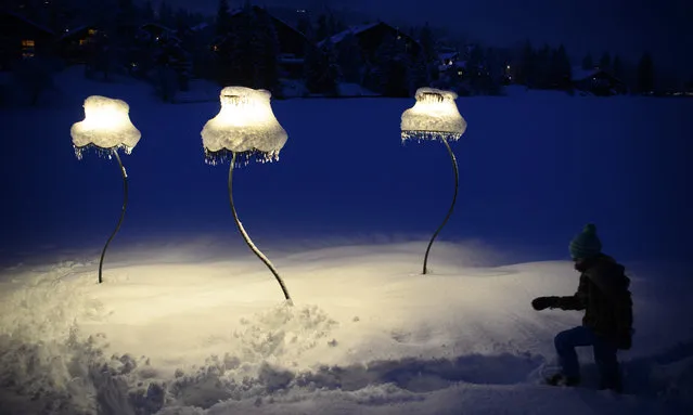 People walk the two-kilometre-long snow-covered Lantern path (Chemin des lanternes) between Lake Moubra and Lake Etang Long during the coronavirus pandemic (COVID-19) in the Alpine resort of Crans-Montana, Switzerland, 30 January 2021. Due to the pandemic related closures, many Swiss citizens seek refuge in the mountains, walk in nature and enjoy the winter snow at night. (Photo by Laurent Gillieron/EPA/EFE)
