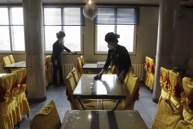 In this February 5, 2021, file photo, staff of the Pongnam Noodle House disinfect the tables and windows of the restaurant in Pyongyang, North Korea. U.N. human rights investigators have asked North Korea to clarify whether it has ordered troops to shoot on sight any trespassers who cross its northern border in violation of the country's pandemic closure. (Photo by Jon Chol Jin/AP Photo/File)