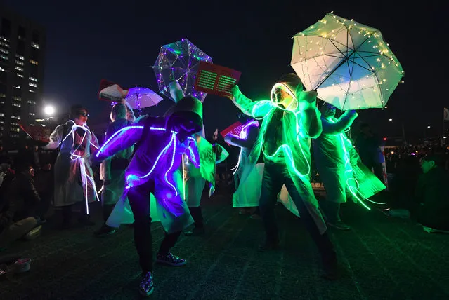 South Korean demonstrators wearing illuminated costumes take part in a candlelit rally demanding arrest of the impeached-president Park Geun-Hye in Seoul on March 10, 2017 after the announcement of the Constitutional Court's decision to uphold the impeachment of South Korea's President Park Geun-Hye. South Korean President Park Geun-Hye was fired on March 10 as a court upheld her impeachment over a corruption scandal that has paralysed the nation at a time of mounting tensions in East Asia. (Photo by Jung Yeon-Je/AFP Photo)
