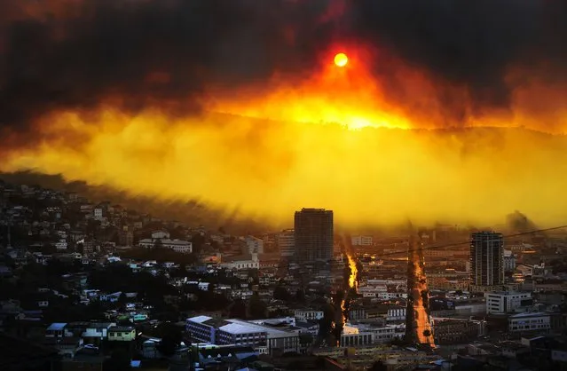 A general view shows a fire in Valparaiso, 110 km west of Santiago, Chile, on April 12, 2014. Authorities decreed a red alert for the area after the fire consumed more than 100 houses. (Photo by Alberto Miranda/AFP Photo)