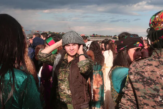 A Kurdish fighter from the People's Protection Units (YPG) takes part during a celebration for the spring festival of Newroz, in the northeastern Syrian city of Qamishli near the Turkish border, Syria on March 21, 2017. (Photo by Rodi Said/Reuters)