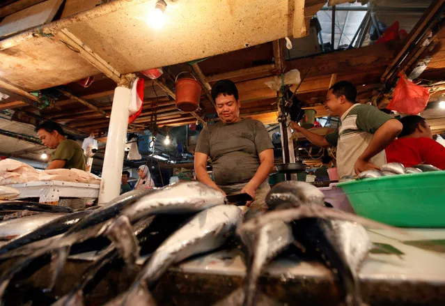 A fishmonger cleans fish at Senin Market in Jakarta, Indonesia, January 31, 2017. Picture taken January 31, 2017. (Photo by Fatima El-Kareem/Reuters)