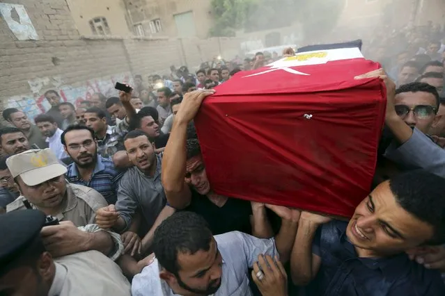 Relatives of 21-year-old Mohamed Adel, one of the army officers who died in yesterday's Sinai attacks, carry his coffin during the funeral in Al-Kaliobeya, near Cairo, Egypt, July 2, 2015. (Photo by Mohamed Abd El Ghany/Reuters)