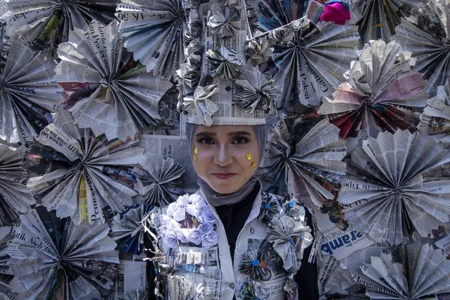 An Acehnese student wearing clothing made from used paper participate in a carnival to celebrate the 74th Indonesian Independence Day in Lhokseumawe, Aceh province, Indonesia on August 18, 2019. In this carnival, thousands of students use various types of traditional Indonesian costumes, and modern clothing designed from used paper. (Photo by Zikri Maulana/ZUMA Press)