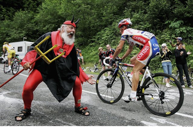 Didi Senft, a cycling enthusiast better known as “El Diablo” (The Devil), jumps as the pack of riders cycles during the twelfth 218km stage of the centenary Tour de France cycling race from Fougeres to Tours July 11, 2013. (Photo by Eric Gaillard/Reuters)