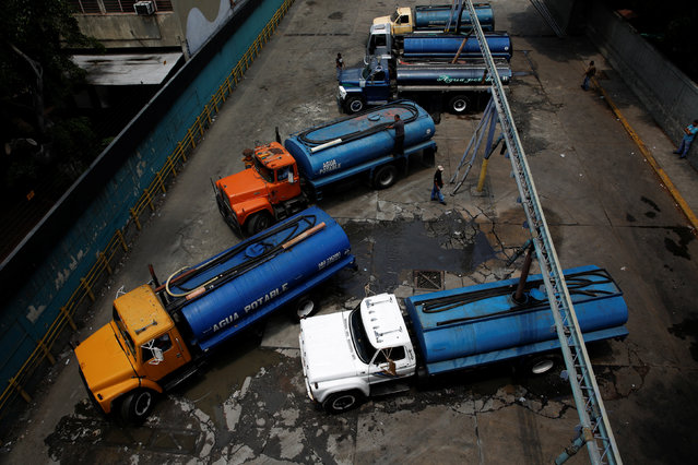 Workers fill water tank trucks at a filling centre in Caracas, Venezuela, March 18, 2016. (Photo by Carlos Garcia Rawlins/Reuters)