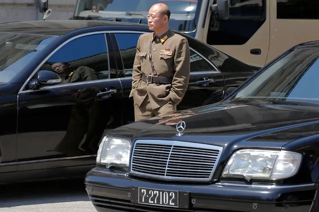A military man stands among black Mercedes-Benz sedans, with the 727 number plates, reserved for the highest government officials, outside the People's Palace of Culture in central Pyongyang, North Korea May 8, 2016. (Photo by Damir Sagolj/Reuters)