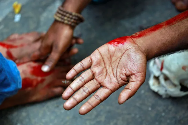 A farmer from the southern state of Tamil Nadu rubs blood on a fellow protestors feet after deliberately cutting himself with a razor blade during a protest demanding a drought-relief package from the federal government, in New Delhi, India April 7, 2017. (Photo by Cathal McNaughton/Reuters)