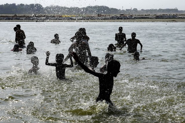 People bathe in the river Ganges to cool themselves off as northern India continues to reel under intense heat wave, Prayagraj, Uttar Pradesh state, India, Monday, June 17, 2024. (Photo by Rajesh Kumar Singh/AP Photo)