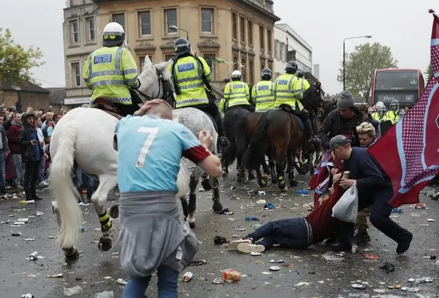 Britain Soccer Football, West Ham United vs Manchester United, Barclays Premier League, Old Trafford on May 10, 2016. A West Ham fan lies on the ground as fans clash with police outside the stadium before the match. (Photo by Eddie Keogh/Reuters/Livepic)