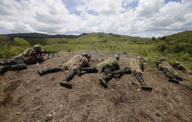 Filipino soldiers fire their weapons at a mock target during a live-fire exercise with their US counterpart at the ongoing joint U.S.-Philippines military exercise dubbed Balikatan 2014, Saturday, May 10, 2014 at the Philippine Army training camp at Fort Magsaysay, Nueva Ecija province in northern Philippines. (Photo by Bullit Marquez/AP Photo)