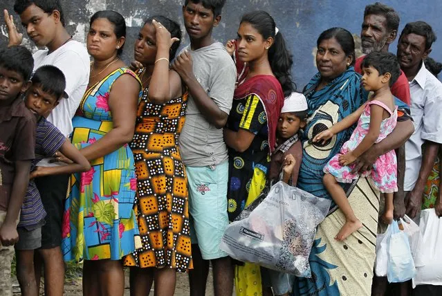 Sri Lankan flood victims line up to receive relief materials in a flood affected area near Colombo, Sri Lanka, Sunday, May 22, 2016. Sri Lanka's soldiers continued searching for scores of people missing since deadly landslides struck hill country several days ago leaving dozens dead. (Photo by v/AP Photo)