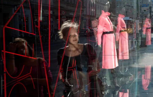 Pedestrians are reflected in the window of a clothes shop at Berlin's Rosenthaler street September 16, 2012. (Photo by Fabrizio Bensch/Reuters)