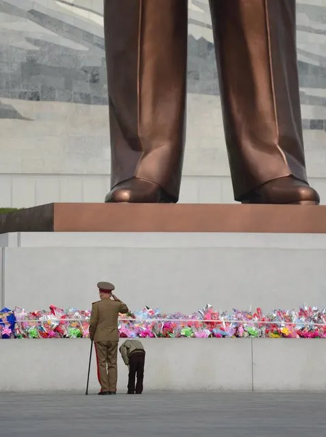 A Korean War veteran and his grandson pay their respects to the leaders of North Korea at the Mansudae Hill Grand Monument in Pyongyang. (Photo by Gavin John/Mediadrumworld.com)