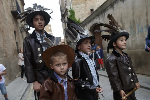 Children dressed as Zarrons prepare to chase other children during the Zarron festival for children on May 17, 2017 in Almazan, Soria province, Spain. El Zarron of Almazan Festival is a shepherds tradition just over 200 hundred years old that honours Saint Pascual Bailon. On its origins shepherds founded a Saint Pascual Bailon brotherhood and started parading a figure representing their Saint around the village. El Zarron is a character that represents the shepherds and wears beard, a hat with vulture feathers and a sheep or fox tail and leather clothes. Members of the brotherhood throw sweets ahead of the procession, and the Zarron has to clear the way of young people with a “zambomba” attached to his stick. (Photo by Pablo Blazquez Dominguez/Getty Images)