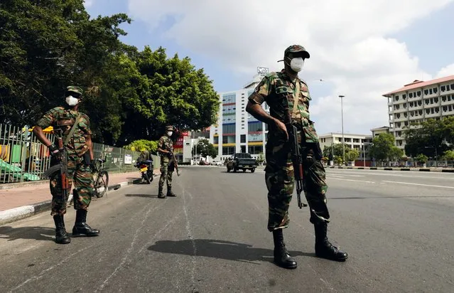 Sri Lankan army soldiers stand guard at a checkpoint after the government imposed a curfew following a clash between police and protestors near Sri Lankan President Gotabaya Rajapaksa's residence during a protest last Thursday, amid the country's economic crisis, in Colombo, Sri Lanka on April 3, 2022. (Photo by Dinuka Liyanawatte/Reuters)
