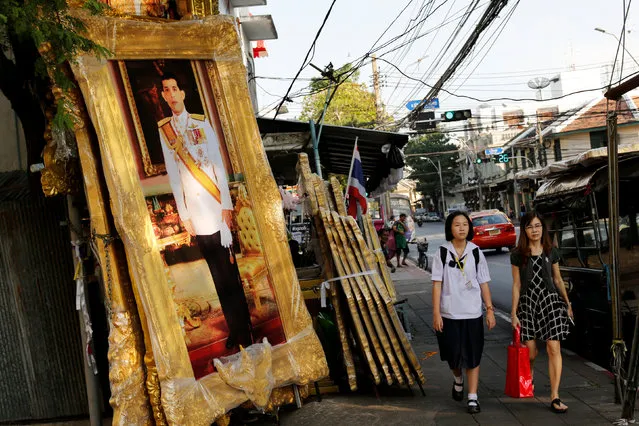 People walk past a picture of Crown Prince Maha Vajiralongkorn displayed for sale at a royal memorabilia shop in Bangkok, Thailand, November 29, 2016. (Photo by Jorge Silva/Reuters)