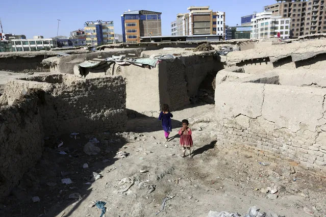 In this Monday, May 30, 2016 photo, Afghan girls play near their temporary home in a camp for internally displaced people in Kabul, Afghanistan. (Photo by Rahmat Gul/AP Photo)