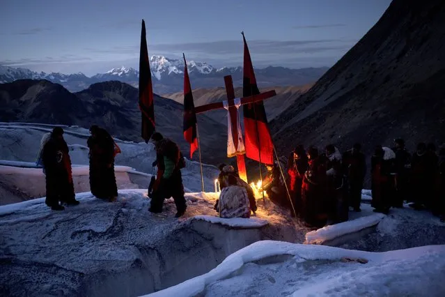 In this May 24, 2016 photo, “Ukukus”, men dressed as mythical half-man, half-bear creatures, light candles on the glacier of the Qullqip'unqu mountain, as part of the syncretic three-day festival Qoyllur Rit’i, translated from the Quechua language as Snow Star, in the Sinakara Valley, in Peru's Cusco region. In recent years, the pilgrims have noted a decline in the size of the glaciers because of warming trends. In hopes of preventing additional ice melting, the ukukus no longer use the large candles that were once common in the ritual. (Photo by Rodrigo Abd/AP Photo)