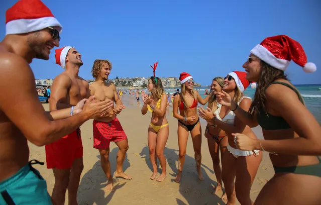 Spanish tourists wearing Christmas outfits dance on Christmas Day at Bondi Beach in Sydney, Australia, 25 December 2019. (Photo by Steven S​aphore/EPA/EFE)