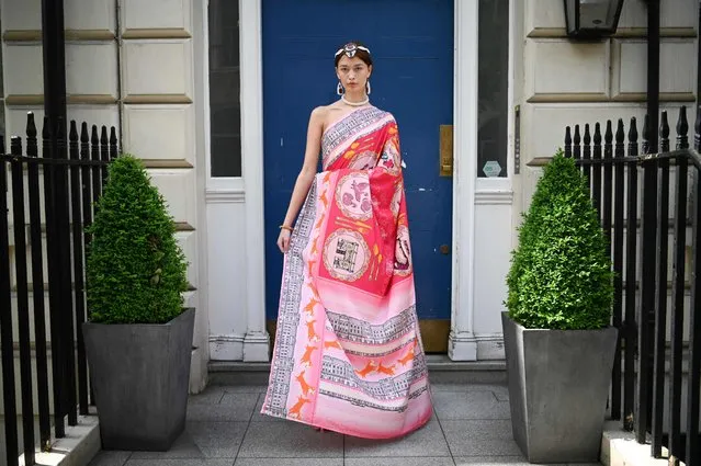 A model wears an outfit chosen by fashion designer Paul Costelloe, for The worlds first Platinum Jubilee Sustainable Sari and designed by London based Nutkhut and Arts University Bournemouth fashion students, as she poses during a photo call in west London, on May 16, 2022. The design of the sari embodies the spirit of the Platinum Jubilee and the Commonwealth, and is made from sustainable recycled plastics. (Photo by Daniel Leal/AFP Photo)