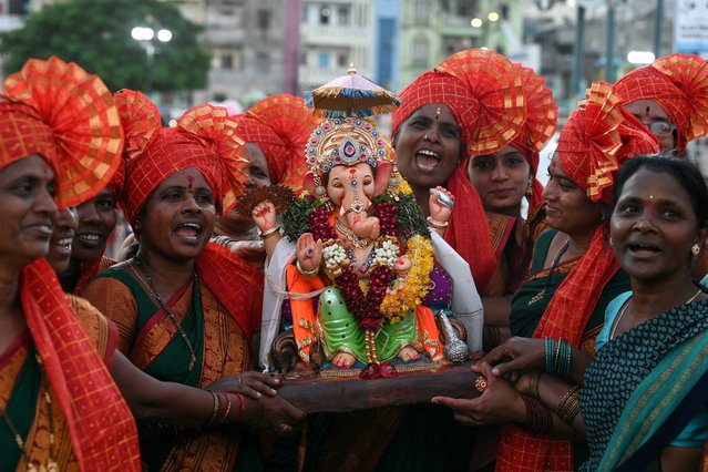 Devotees carry an idol of the Hindu deity Ganesha for immersion at Hussain Sagar lake during the “Ganesh Chaturthi” festival in Hyderabad on September 13, 2024. (Photo by Noah Seelam/AFP Photo)