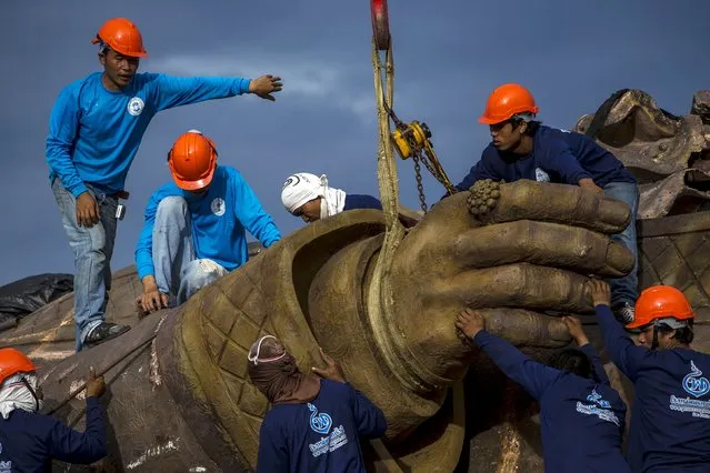 Labourers use a crane to lift the hand of a giant bronze statue of former King Rama I at Ratchapakdi Park in Hua Hin, Prachuap Khiri Khan province, Thailand, August 4, 2015. (Photo by Athit Perawongmetha/Reuters)