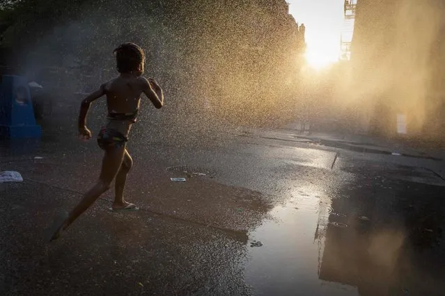 A young girl runs through a sprinkler at a playground in the Brooklyn borough of New York July 7, 2014. (Photo by Brendan McDermid/Reuters)