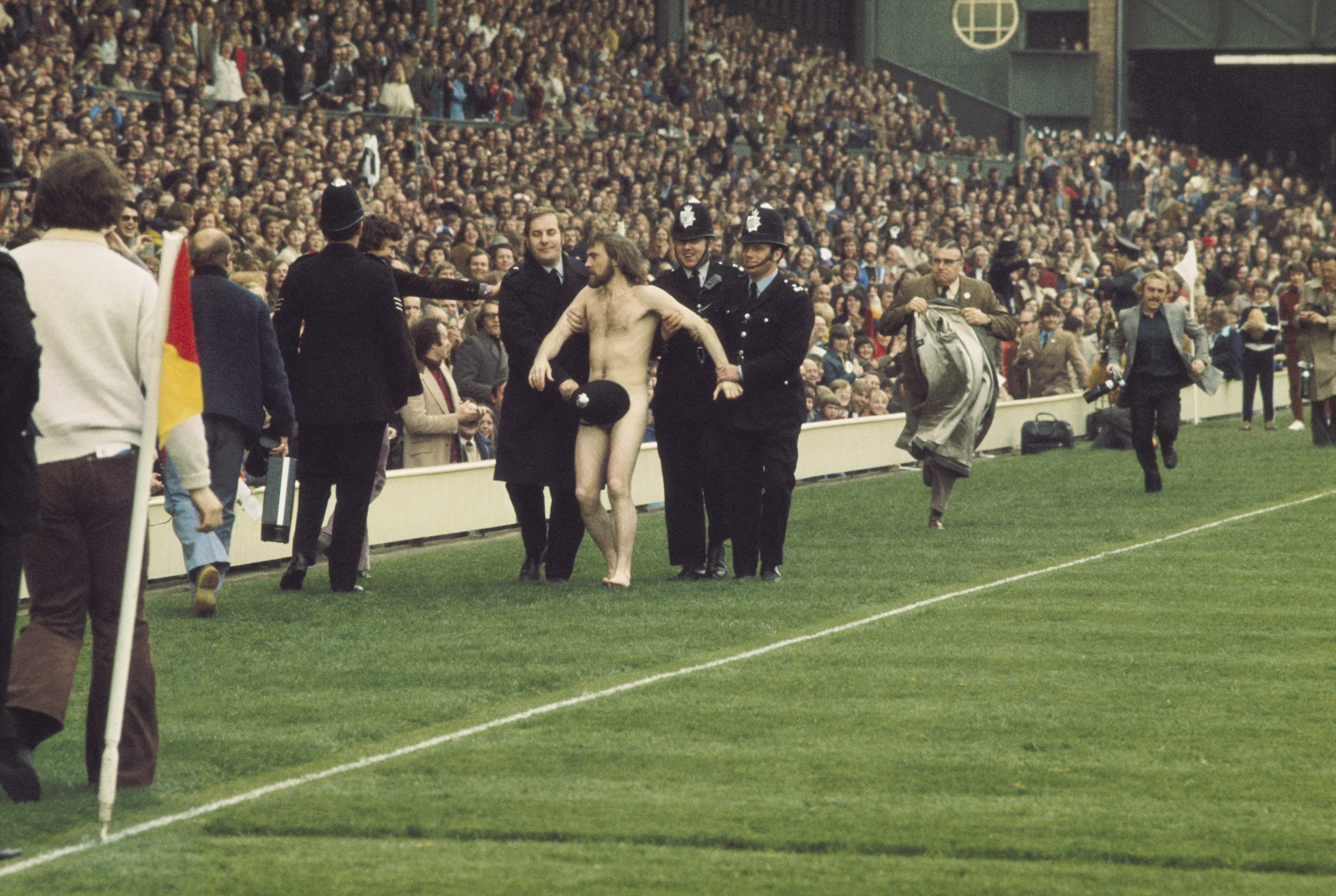 A streaker at Twickenham is discretely led off by police during the England...