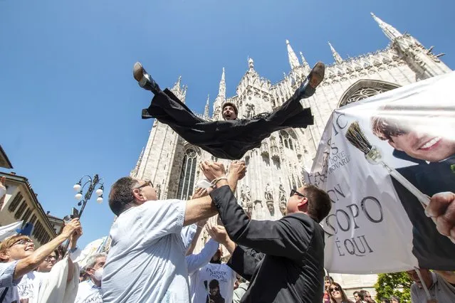 A newly ordained priest is thrown in the air in celebration in front of Milan's gothic cathedral, Italy, Saturday, June 11, 2022. (Photo by Ermes Beltrami/LaPresse via AP Photo)