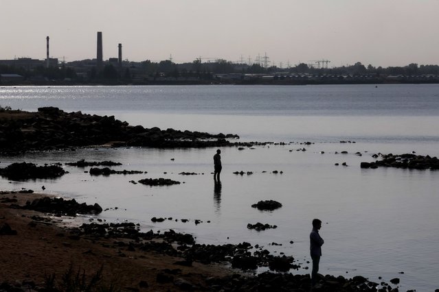 Men stand on the shore of the Gulf of Finland during warm weather in St. Petersburg, Russia, 11 September 2024. Temperatures in Russia's second-largest city reached up to 23 degrees Celsius. (Photo by Anatoly Maltsev/EPA/EFE)