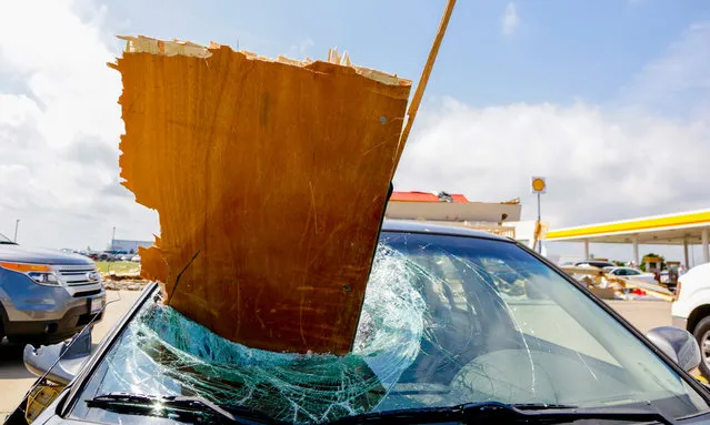 A car's windshield is pierced by a board Thursday, June 23, 2016, in Pontiac, Ill., after it was damaged Wednesday night by a tornado. The tornado that cut a more than 11-mile path through the Pontiac area was rated an EF-2 with estimated top wind speeds of 115 to 125 mph. (Photo by Teresa Crawford/AP Photo)