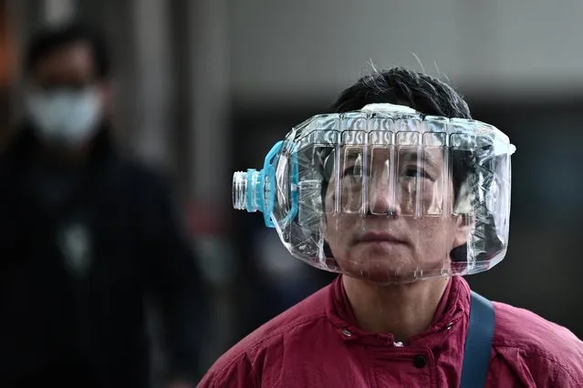 A woman wears a plastic water bottle with a cutout to cover her face, as she walks on a footbridge in Hong Kong on January 31, 2020, as a preventative measure following a virus outbreak which began in the Chinese city of Wuhan. The World Health Organization, which initially downplayed the severity of a disease that has now killed 170 nationwide, warned all governments to be “on alert” as it weighed whether to declare a global health emergency. (Photo by Anthony Wallace/AFP Photo)