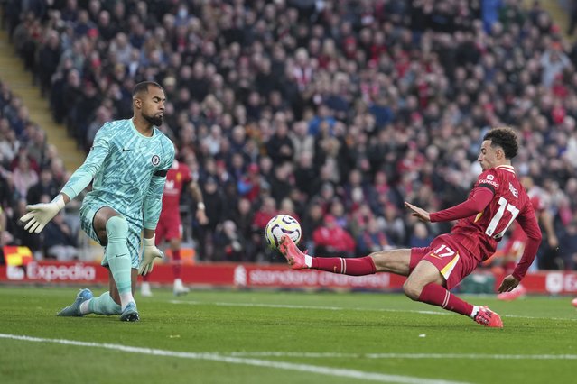 Liverpool's Curtis Jones, right, scores his side's second goal past Chelsea's goalkeeper Robert Sanchez during the English Premier League soccer match between Liverpool and Chelsea at Anfield Stadium, Liverpool, England, Sunday, October 20, 2024. (Photo by Jon Super/AP Photo)