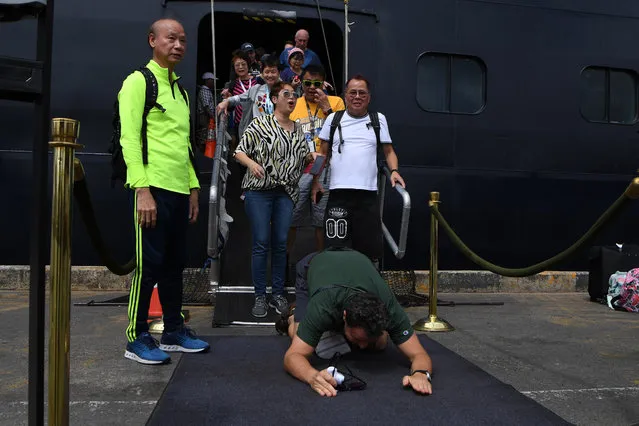A passenger reacts as he disembarks from the Westerdam cruise ship in Sihanoukville on February 14, 2020, where the liner docked after being refused entry at other Asian ports due to fears of the COVID-19 coronavirus outbreak. Cambodia's strongman premier Hun Sen welcomed on February 14 the passengers of a US cruise ship blocked from several Asian ports over fears of a deadly new virus. (Photo by Tang Chhin Sothy/AFP Photo)