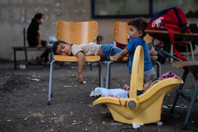 A young boy sleeps on chairs in the school where his family are sheltering after being displaced by Israeli airstrikes, on October 12, 2024 in Sidon also known as Saida, Lebanon. At this displaced persons camp here, the charity Action for Humanity provides shelter, meals and other aid to over 700 people who have fled from other parts of Lebanon that are bearing the brunt of Israel's escalating war with Hezbollah. The war has displaced hundreds of thousands of Lebanese, according to the UN migration agency, with many fleeing southern areas to cities like Sidon. (Photo by Carl Court/Getty Images)