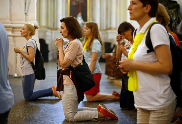 People pray in a Catholic church during the annual Icon of the Mother of God festival in the village of Budslav, Belarus July 1, 2016. (Photo by Vasily Fedosenko/Reuters)