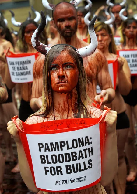 Animal rights protesters covered in fake blood demonstrate for the abolition of bull runs and bullfights a day before the start of the famous running of the bulls San Fermin festival in Pamplona, northern Spain, July 5, 2016. (Photo by Eloy Alonso/Reuters)
