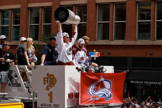Erik Johnson (6) hoists the cup as he sits atop the shoulders of the captain Gabriel Landeskog (92), while partying alongside Nathan MacKinnon (29) during the Colorado Avalanche Stanley Cup celebration parade in downtown Denver on Thursday, June 30, 2022. (Photo by  Isaiah J. Downing/USA TODAY Sports)