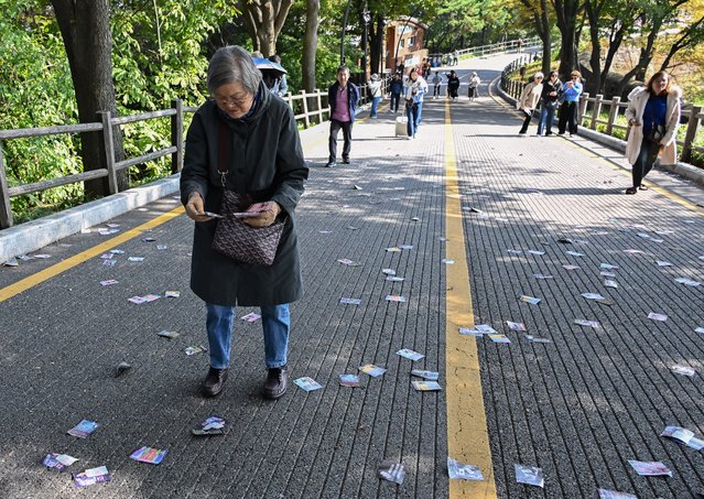 On the morning of the October 24, 2024, a tourist picks up and examines a leaflet believed to have been dropped by North Korea using a waste balloon on a walking path near Seoul Tower in Namsan, Seoul. (Photo by Koh Woon-ho)