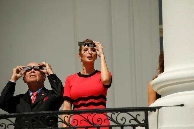 Ivanka Trump and Commerce Secretary Wilbur Ross wear special glasses to look up at the Solar Eclipse, at the White House on August 21, 2017 in Washington, DC. Millions of people have flocked to areas of the U.S. that are in the 'path of totality' in order to experience a total solar eclipse. (Photo by Kevin Lamarque/Reuters)
