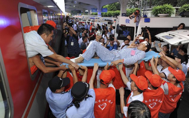 An injured man is carried out of a train, after being transported from quake-hit Ludian county to Yibin for medical treatments, in Yibin, Sichuan province province August 6, 2014. An earthquake in China on the weekend triggered landslides that have blocked rivers and created rapidly growing bodies of water that could unleash more destruction on survivors of the disaster that killed 589 people, state media reported on Tuesday. (Photo by Reuters/Stringer)