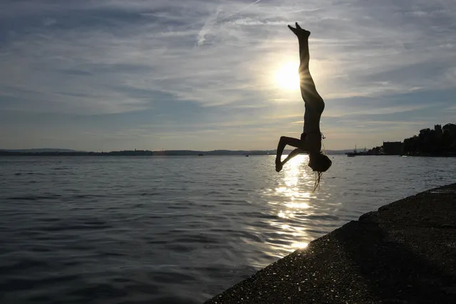 A woman jumps into the Lake Constance in Meersburg, southern Germany, on July 10, 2016. (Photo by Felix Kästle/AFP Photo/DPA)