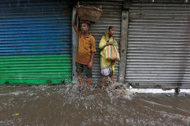 Vendors stand in front of closed shops as it rains in Kolkata, India, July 25, 2016. (Photo by Rupak De Chowdhuri/Reuters)