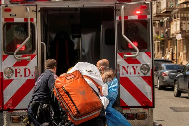 New York City Fire Department (FDNY) and Emergency Medical Technicians (EMT) wearing personal protective equipment lift a man after moving him from a nursing home into an ambulance during an ongoing outbreak of the coronavirus disease (COVID-19) in the Brooklyn borough of New York, U.S., April 16, 2020. (Photo by Lucas Jackson/Reuters)