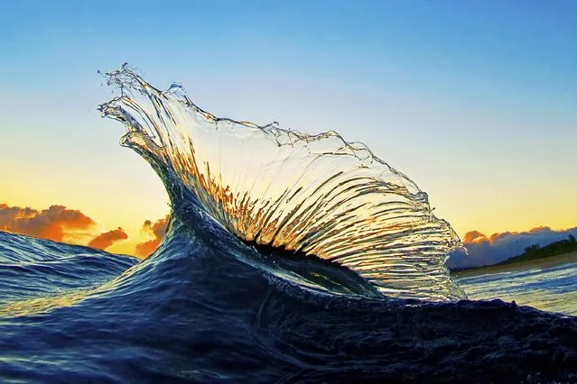 In this undated photo two waves collide at sunrise creating a picturesque splash near Haleiwa, Hawaii. (Photo by Dane Little via AP Photo)
