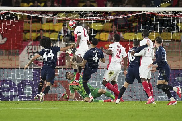 Monaco's Wilfried Singo, top, scores the opening goal of his team during a Champions League opening phase soccer match at the Louis II stadium in Monaco, Tuesday, January 21, 2025. (Photo by Laurent Cipriani*AP Photo)