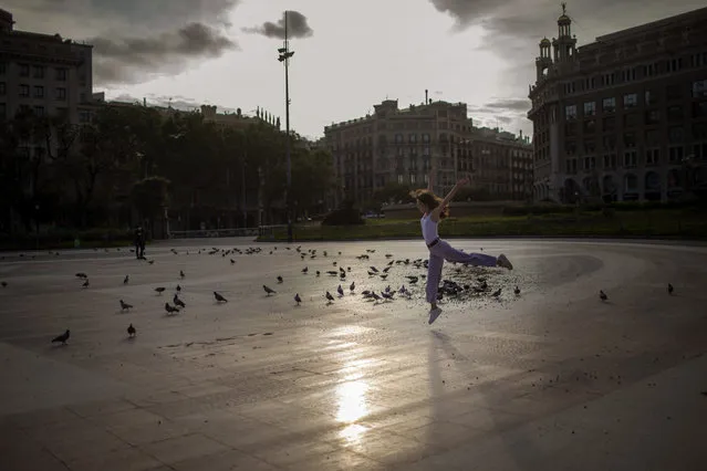 Manon, 13, from France, dances at the Catalunya square in Barcelona, Spain, Monday, April 27, 2020 as the lockdown to combat the spread of coronavirus continues. Health authorities in Spain are urging parents to be responsible and abide by social distancing rules a day after some beach fronts and city promenades filled with families eager to enjoy the first stroll out in six weeks. (Photo by Emilio Morenatti/AP Photo)