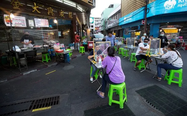 Customers eat street food behind plastic sheets to help curb the spread of the coronavirus in Bangkok, Thailand, Tuesday, May 12, 2020. Small restaurants are one of the few businesses that have been allowed to open during an easing of restrictions in Thailand's capital Bangkok imposed weeks ago to combat the spread of the coronavirus. (Photo by Sakchai Lalit/AP Photo)
